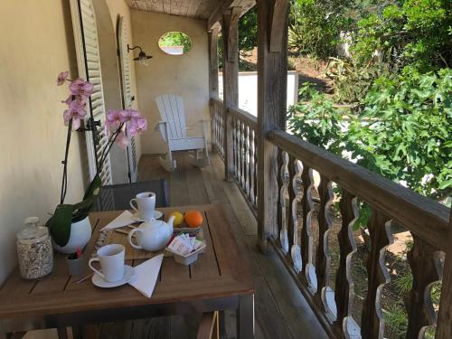 a table on a porch with a tea set on it at Le Clos des Sept Palmiers in Cavalaire-sur-Mer