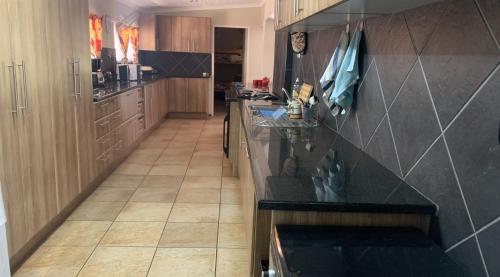 a kitchen with a black counter top and wooden cabinets at Shala Mushe Tented Camp & Camp in Bela-Bela