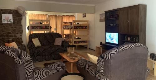 a living room with two couches and a television at Shala Mushe Tented Camp & Camp in Bela-Bela