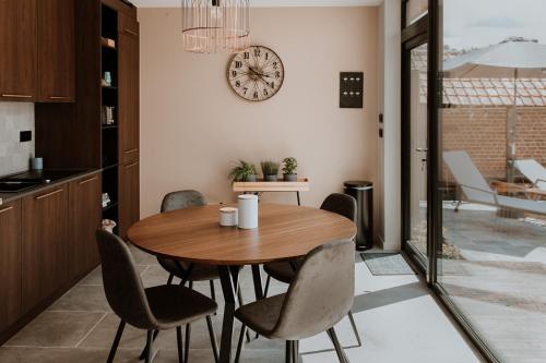 a kitchen and dining room with a wooden table and chairs at Le Repos in Brakel