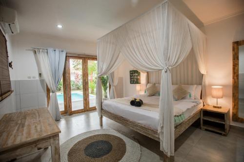 1 dormitorio con cama con dosel y piscina en Villa Piece Of Peace private 3BR with large pool and garden, en Canggu
