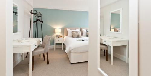 - une chambre avec un lit, un bureau et un miroir dans l'établissement The Bath Arms Hotel, à Cheddar