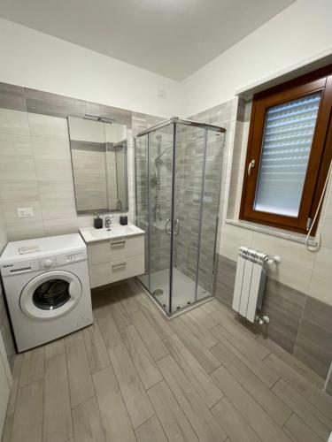 a bathroom with a shower and a washing machine at Artemis Casa Vacanza in Reggio di Calabria