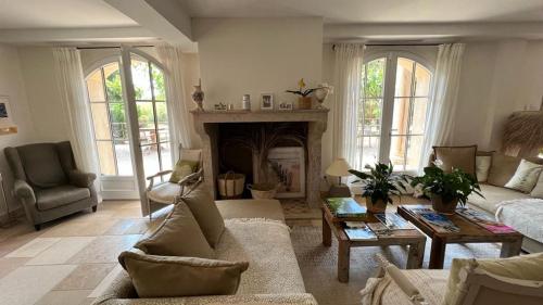 a living room with a couch and a fireplace at Le Clos des Sept Palmiers in Cavalaire-sur-Mer