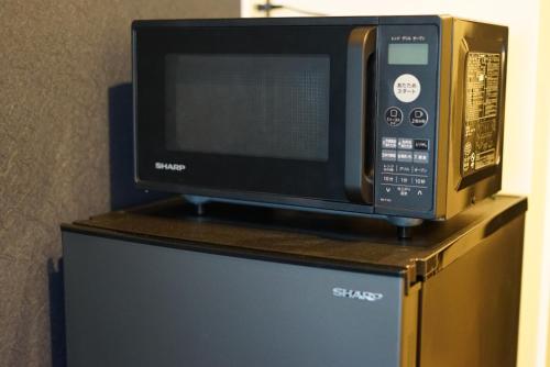 a microwave oven sitting on top of a refrigerator at SETOUCHI SUP RESORT - Ao - in Shodoshima