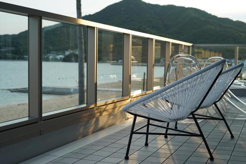 a bench on a balcony with a view of the water at SETOUCHI SUP RESORT - Ao - in Shodoshima