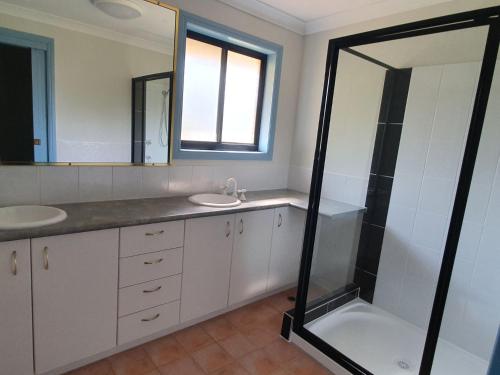 a bathroom with a shower and a sink and a mirror at Sharon Lee 1 in Rainbow Beach