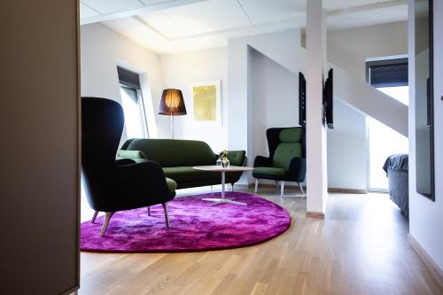 a living room with a couch and a table and chairs at Clarion Hotel Energy in Stavanger