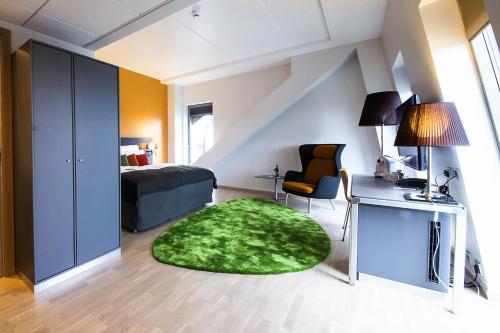 a bedroom with a bed and a green rug at Clarion Hotel Energy in Stavanger
