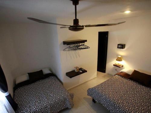 1 dormitorio con 2 camas y mesa en la pared en rooms the batey, en Cancún
