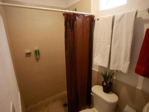 y baño con ducha, aseo y toallas.  en rooms the batey, en Cancún