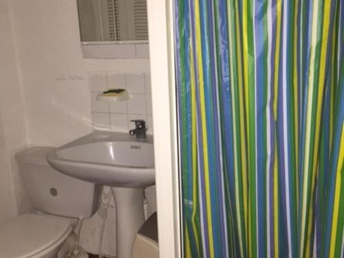 La salle de bains est pourvue d'un lavabo, de toilettes et d'un rideau de douche. dans l'établissement Studio 2 Pers, Piscine, Parking, Animaux admis - FR-1-81-245, au Barcarès