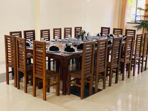 a dining room table with chairs and a long table at Yal's Town Inn in Jaffna