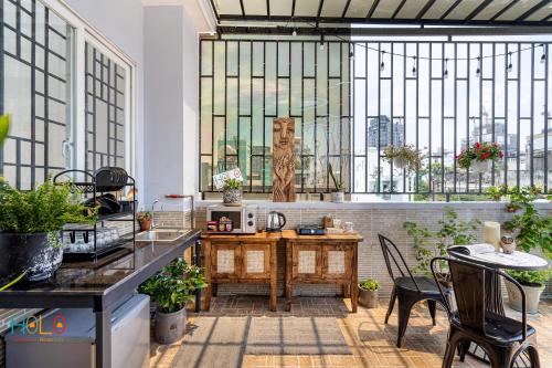 ホーチミン・シティにあるHoLo Central Saigon - Serviced HomeStayのキッチン(テーブル、椅子、窓付)