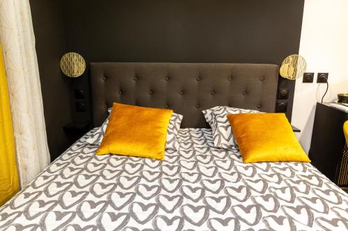 a bed with two orange pillows on top of it at La Golden Room in Avignon