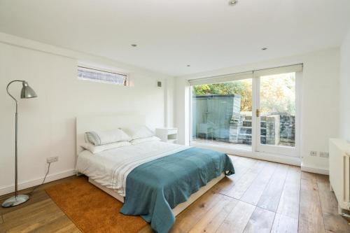 a white bedroom with a bed and a large window at Fantastic 3 Bedroom Flat West Hampstead in London