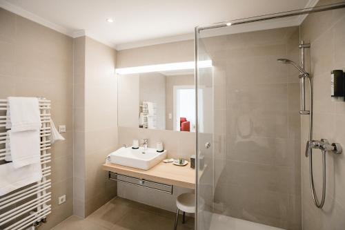 łazienka z umywalką i prysznicem w obiekcie Seehotel Billroth w mieście St. Gilgen