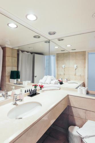 a bathroom with two sinks and a large mirror at Almog Haifa Israel Apartments מגדלי חוף הכרמל in Haifa