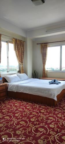 um quarto grande com uma cama grande e janelas em Green Mandala Inn em Catmandu
