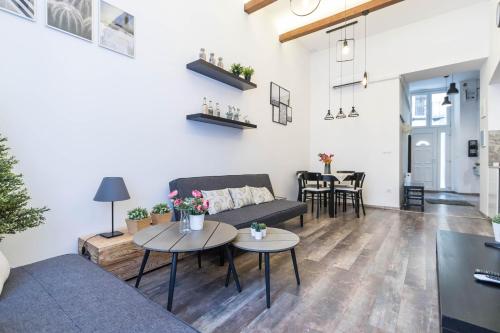 - un salon avec un canapé et des tables dans l'établissement Katarina Apartment Blaha Square, à Budapest