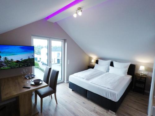 1 dormitorio con 1 cama, escritorio y TV en -Neubau- 30qm Dach-Apartment en Fulda