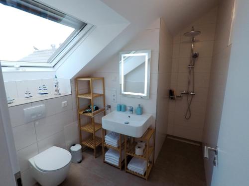 a bathroom with a sink and a toilet and a window at -Neubau- 30qm Dach-Apartment in Fulda