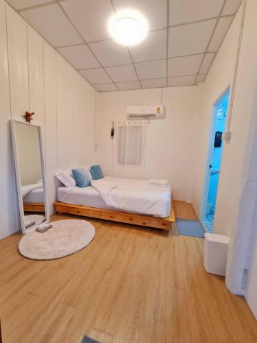 a bedroom with a bed and a mirror in it at Rub Lom Chom Klong Homestay in Chumphon