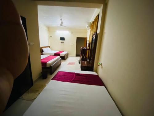 a small room with two beds and a couch at Yal's Town Inn in Jaffna