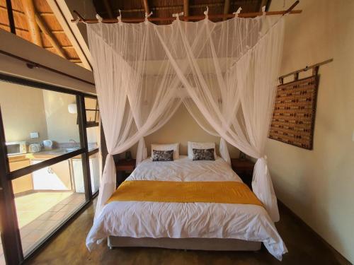 Tempat tidur dalam kamar di Masorini Bush Lodge