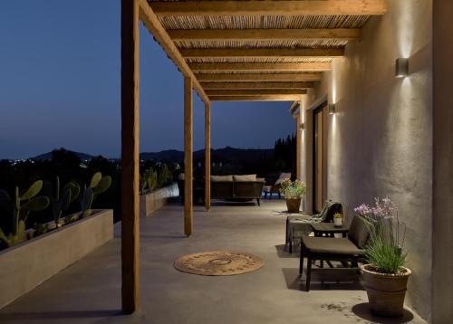 a porch with chairs and a couch on a building at Yliessa - Luxury pool villa surrounded by nature in Dhrákas