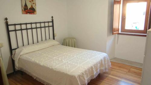 a bedroom with a bed in a room with a window at Casa Florinda Casa con terraza in Lariño