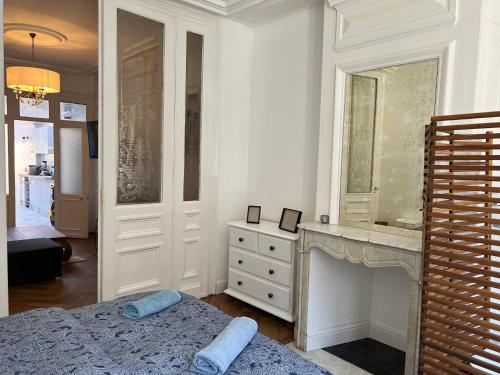 - une chambre avec un lit, une cheminée et un miroir dans l'établissement La petite place de la Porte d'Arras, à Lille
