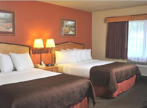 A bed or beds in a room at AmericInn by Wyndham Oswego