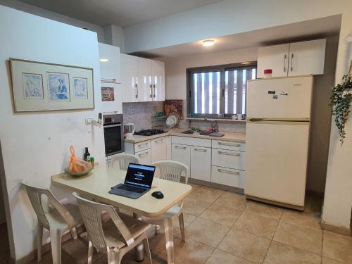 a kitchen with a table with a laptop on it at Lovely Apartment with shalter room in Tel Aviv