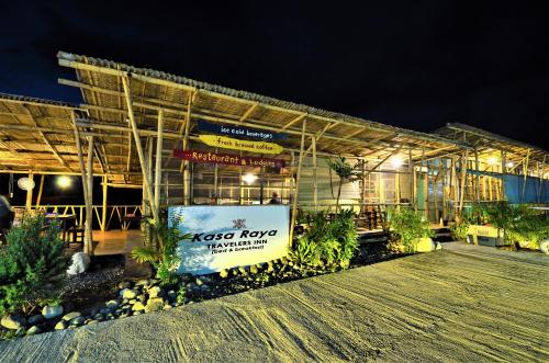 Tibiao的住宿－Kasa Raya Inn，一座建筑,在晚上前有标志