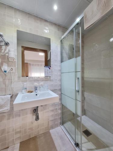 a bathroom with a sink and a shower at Pensión Belmonte II in Benicarló