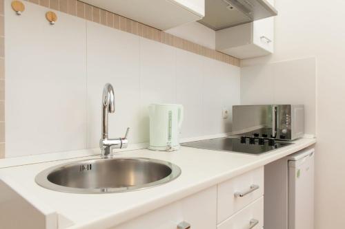 eine Küche mit einer Spüle und einer Mikrowelle in der Unterkunft Apartment Stara vrata in Rijeka