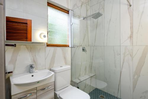a bathroom with a toilet and a sink and a shower at San Lameer Villa 3212 - 4 Bedroom Superior - 8 pax - San Lameer Rental Agency in Southbroom