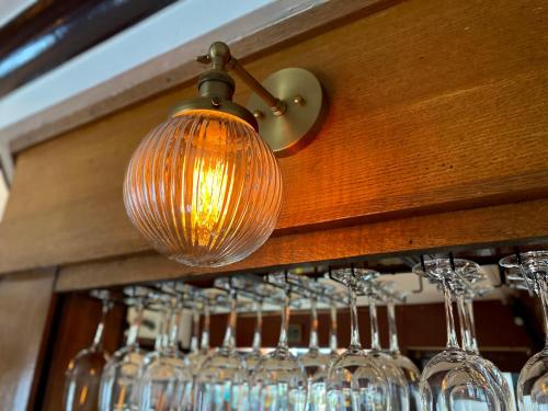 a bunch of wine glasses hanging from a rack at The Gordon Arms Restaurant with Rooms in Yarrow