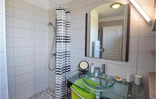 ein Badezimmer mit einem Glaswaschbecken und einem Spiegel in der Unterkunft Nice Home In Crances With Wifi in Créances
