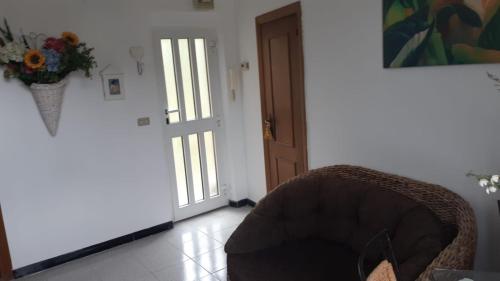 a room with a chair and a door with a vase of flowers at GolfoParadiso Uscio bombon - PellicceriaSuperior in Uscio