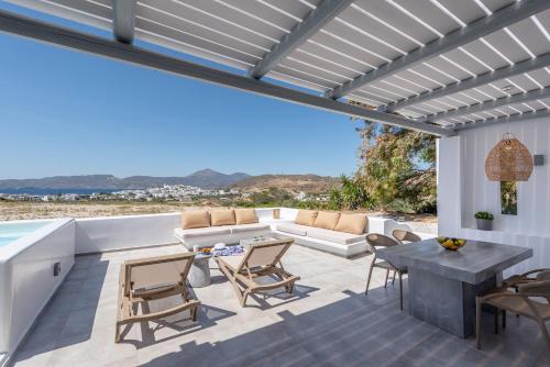 a patio with a couch and a table and chairs at Etereo Suite in Adamas