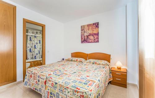 Un dormitorio con una cama con un edredón colorido. en Apartamento de 3 dormitorios, 1º línea de playa en Marina d´Or, en Oropesa del Mar