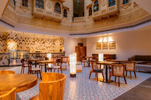 a restaurant with wooden tables and chairs in a room at Rupal Residency in Jaisalmer