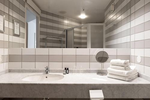 a bathroom with a sink and a mirror and towels at Elite Park Hotel in Växjö