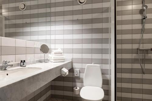 a bathroom with a toilet and a sink and a mirror at Elite Park Hotel in Växjö