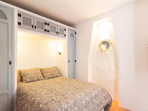 a small bedroom with a bed and a mirror at Casa Las Niñas in Pinos del Valle