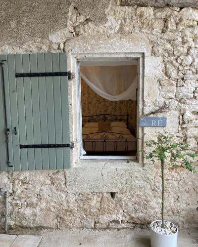 a window in a stone wall with a bed in it at Figtrees in Margueron
