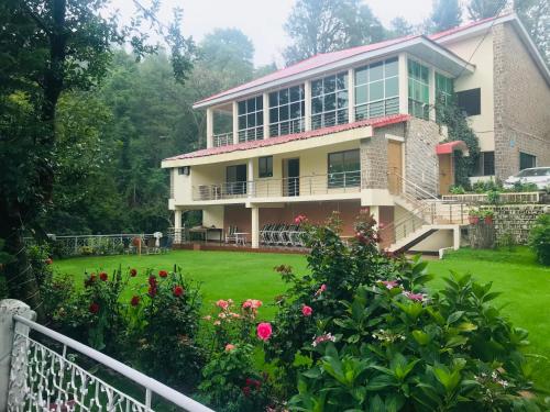 una casa con un patio verde con flores en H.M.H Lodges & Hotel Resort en Murree