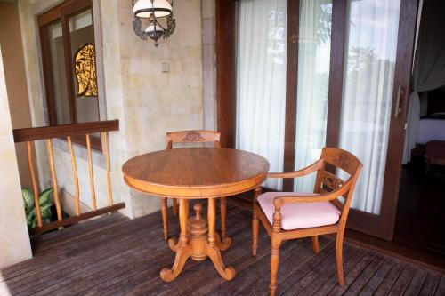 a wooden table and two chairs on a porch at The Kayon Jungle Resort in Ubud